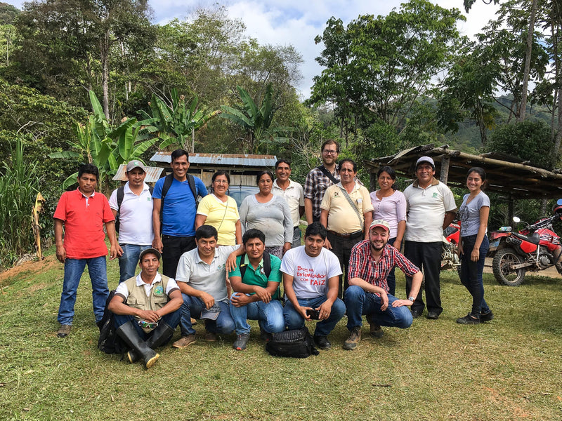 Coffee farmers and cooperative members posing together at the farm